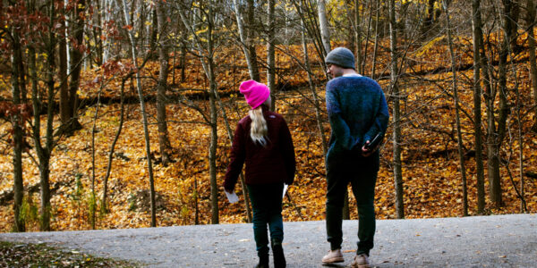 An adult and younger child walking through a path at Evergreen Brick Works in Autumn.